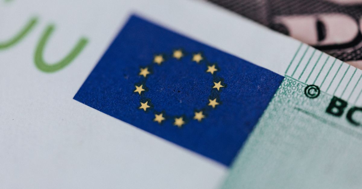 From above of crop banknote of European Union placed on table with dollars
